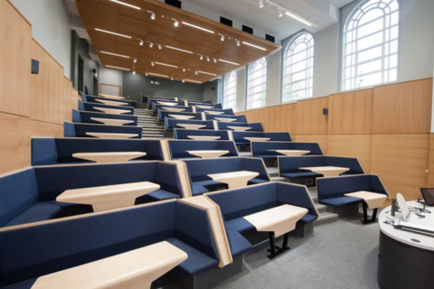 image of a lecture room with tables that seat four students