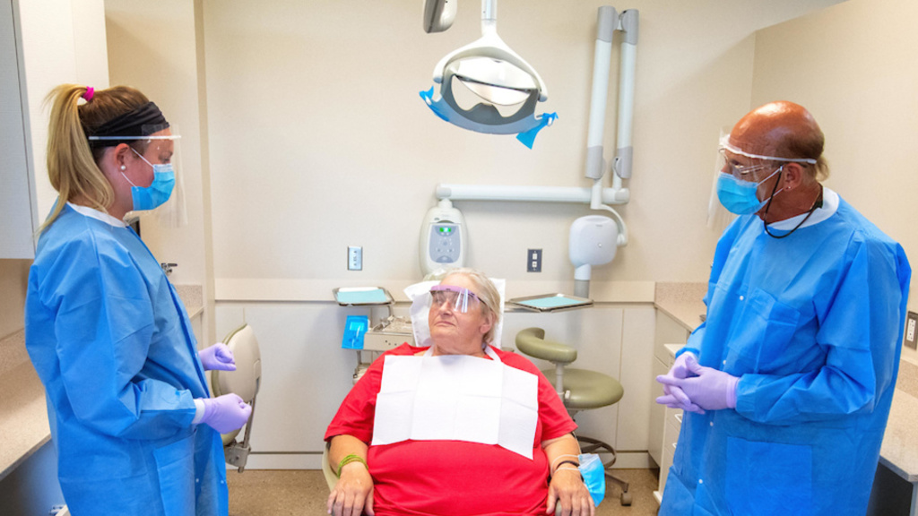 Image of two dentists with patient in exam chair