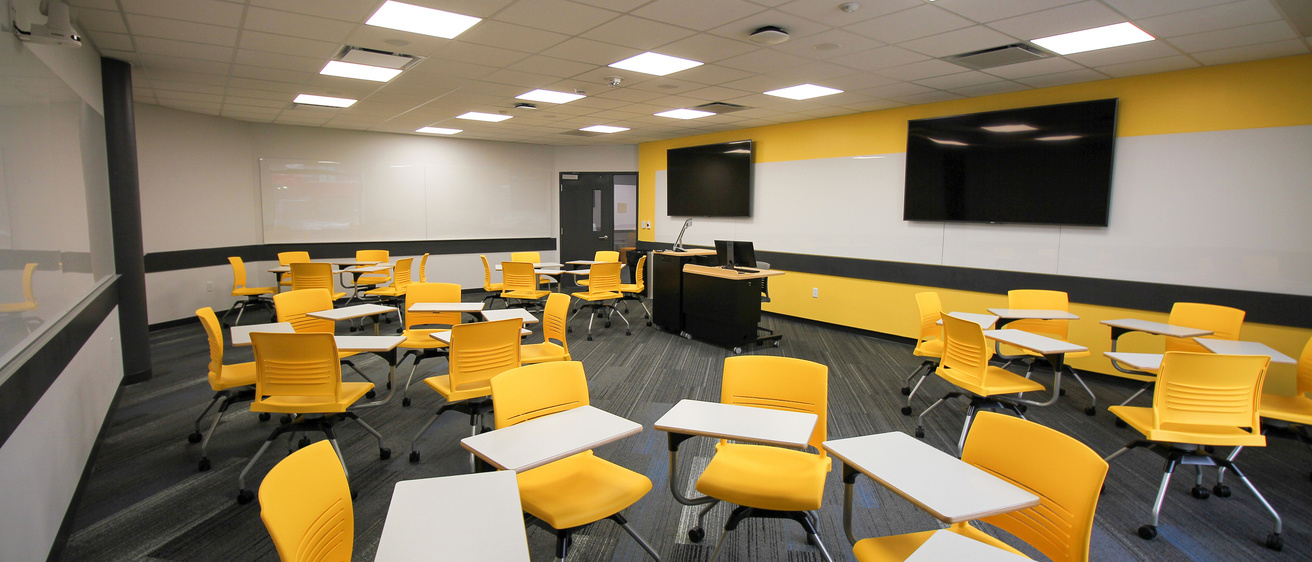 image of classroom with bright yellow tablet arm chairs